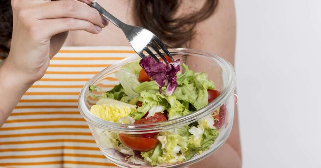 Pessoa praticando exercícios ao ar livre com frutas e vegetais ao fundo