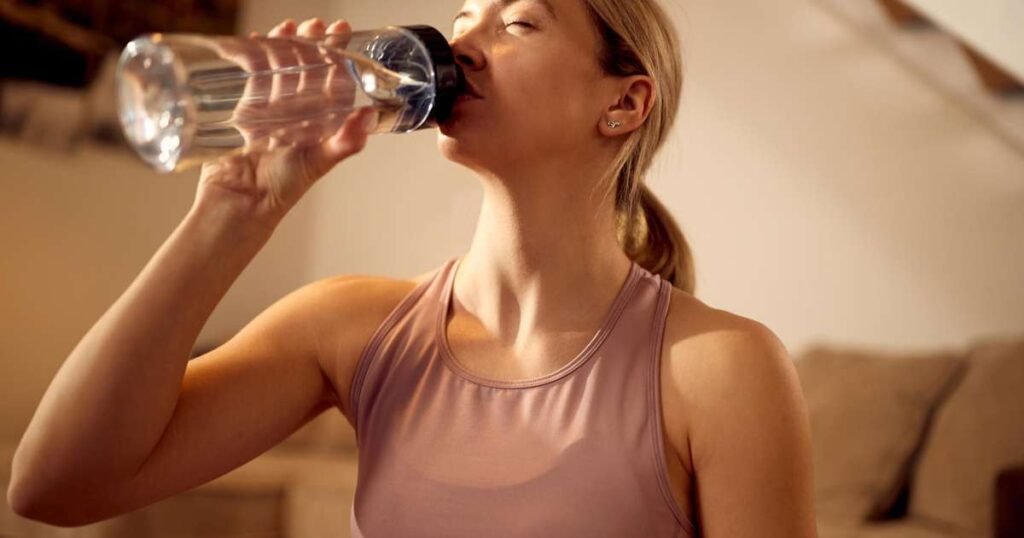 Uma pessoa bebendo um copo de água ao acordar