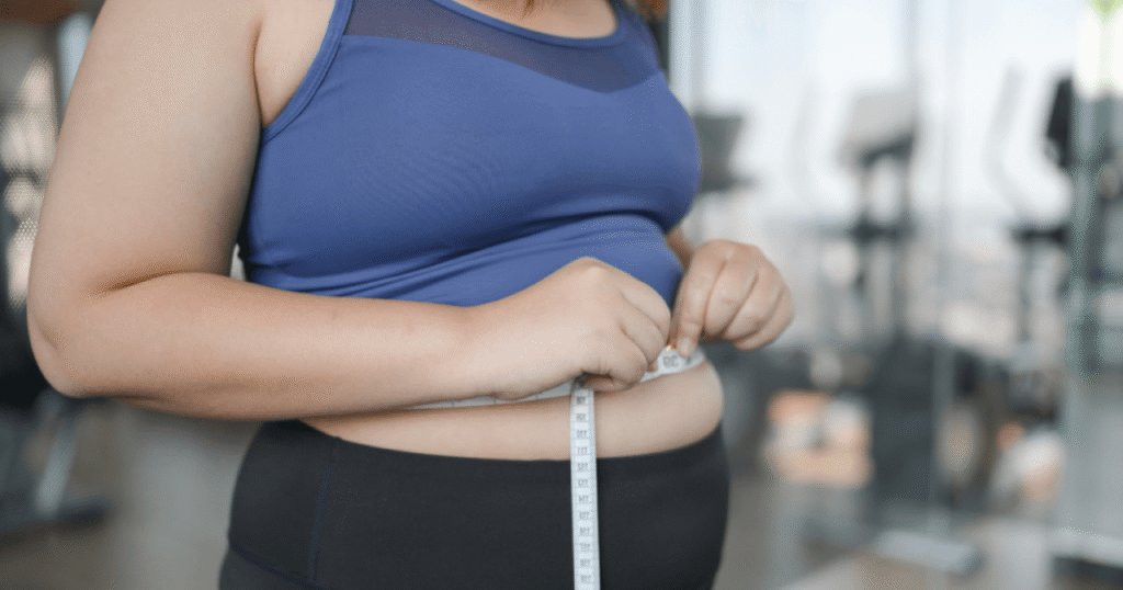 Ilustração representando a relação entre obesidade e câncer, com ícones de alimentos ultraprocessados e células cancerígenas.