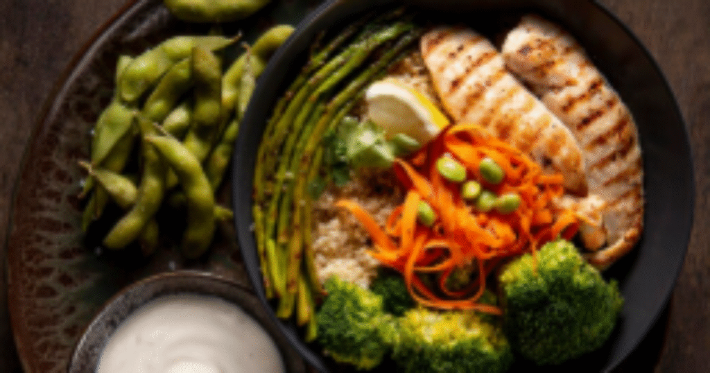 Pessoa segurando um prato com alimentos ricos em proteína, como frango grelhado, ovos e legumes.