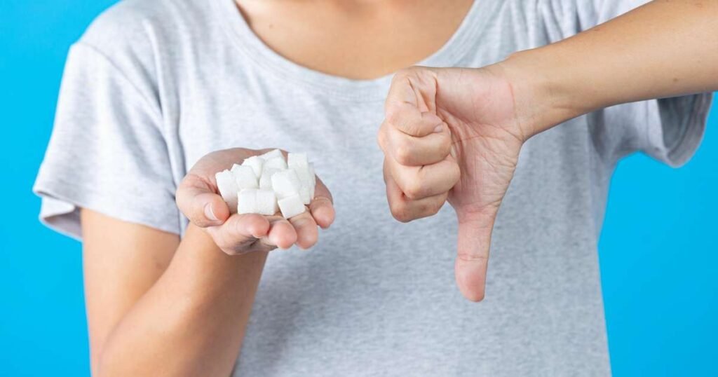 Pessoa segurando uma maçã e cortando um doce, simbolizando a transição para uma dieta sem açúcar.